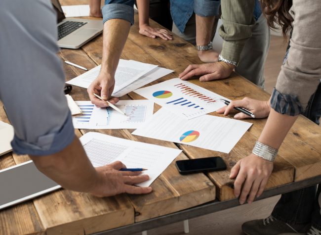 Businessman and woman discussing on stockmarket charts in office